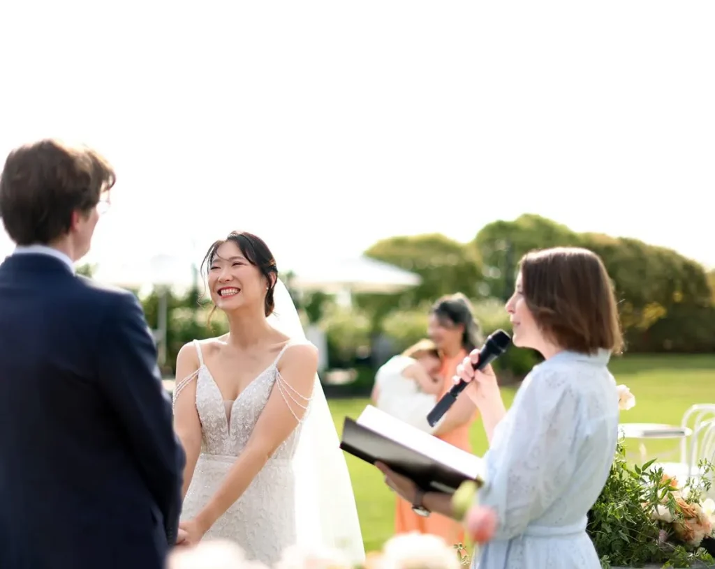 Charis White officiating a beautiful outdoor garden wedding ceremony with smiling bride